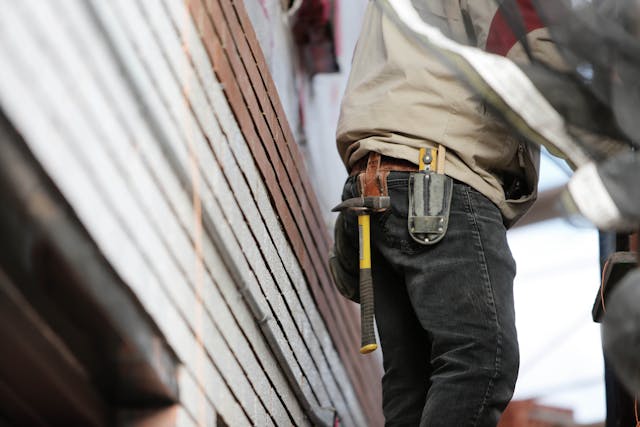 Person wearing a tool belt with a hammer